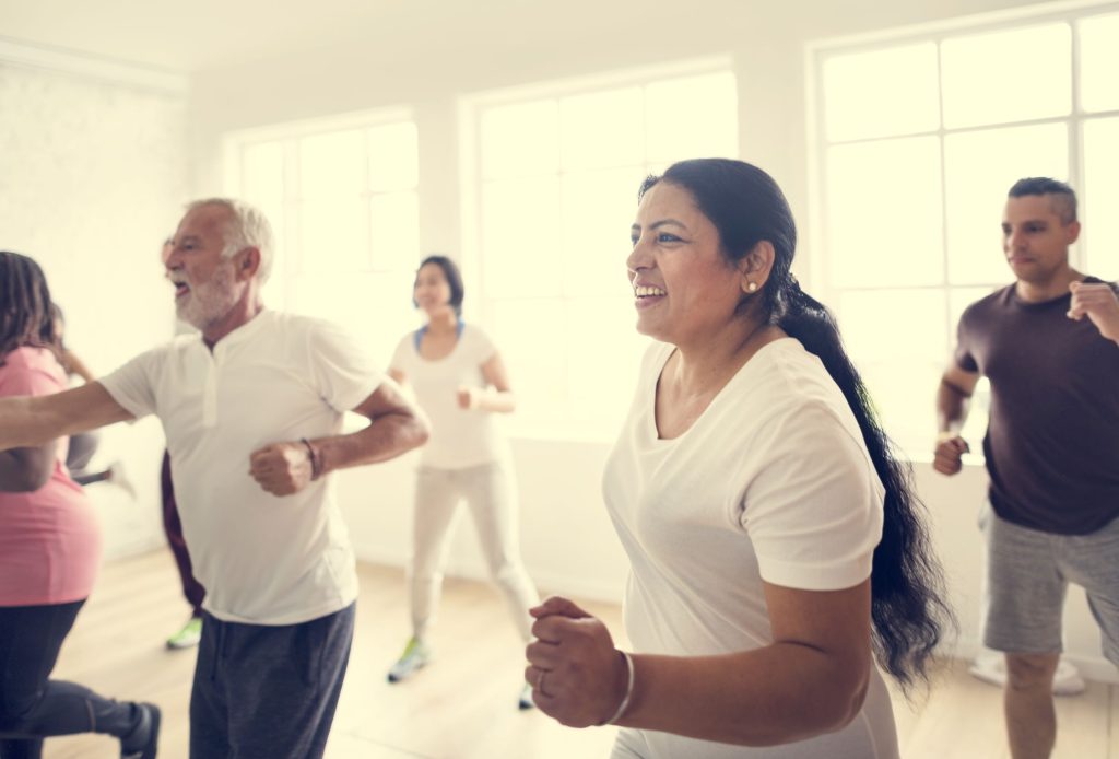Picture of a group of people of different ages and ethnicity exercising.