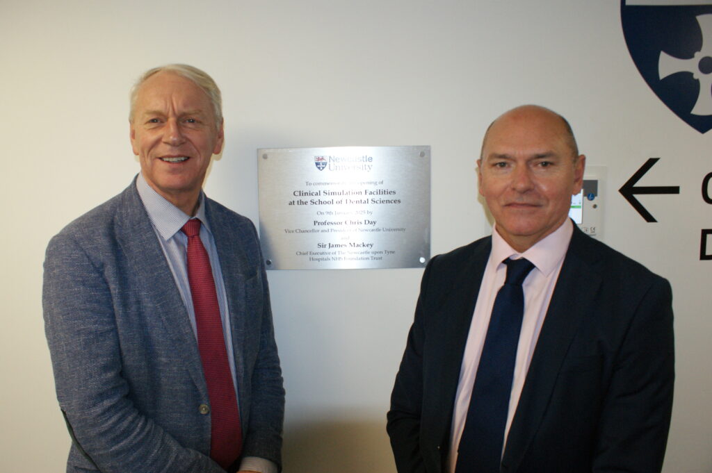 Professor Chris Day and Sir Jim Mackey stand in front of a plaque at the opening of the new dental school training facilities 
