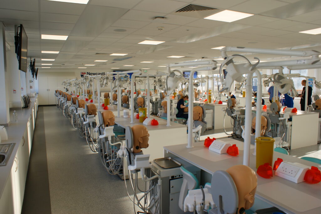 A training facility features simulation heads to allow students to practice dental care on a model