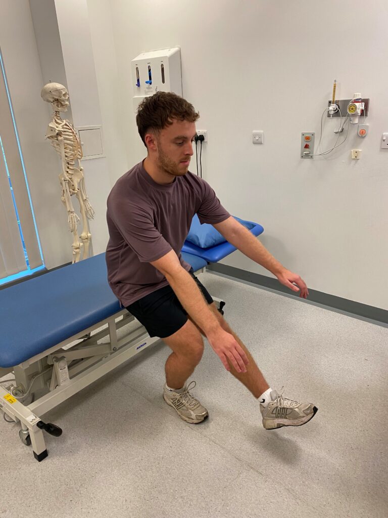 Person stood on one leg bent with one left straight out squatting with hands straight out. 