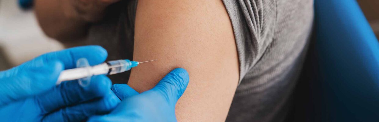 Senior vaccination concept. Doctor giving an injection to older elderly people patient in clinic. Coronavirus Covid 19 vaccine. Doctor making an injection with a syringe