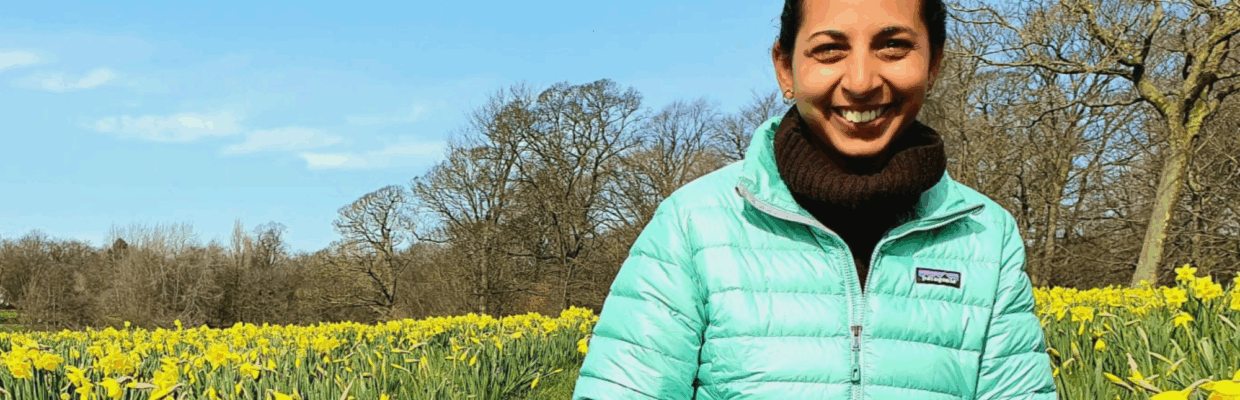 A woman sat in a field with daffodils