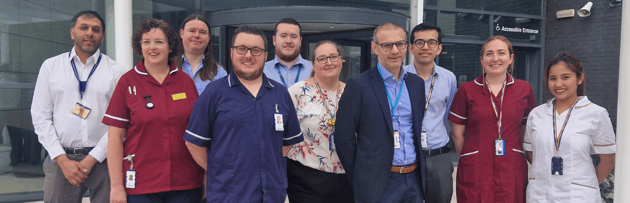 The team involved in recruiting the first patient in the world to a trial stand together outside a building
