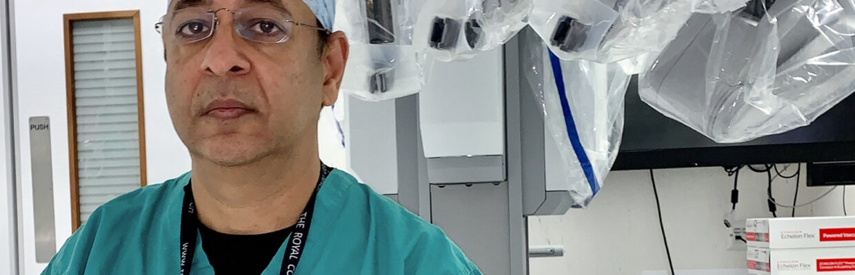 A photo of Dharmendra Agrwal sitting with a medical device behind him