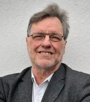A headshot of Sir Paul Ennals