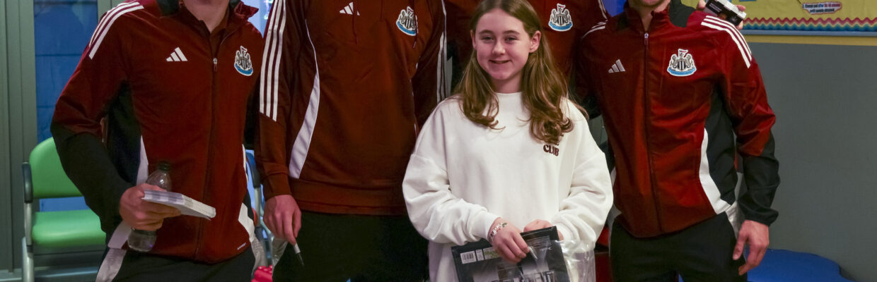 A photo of Newcastle United players with a young girl in the RVI