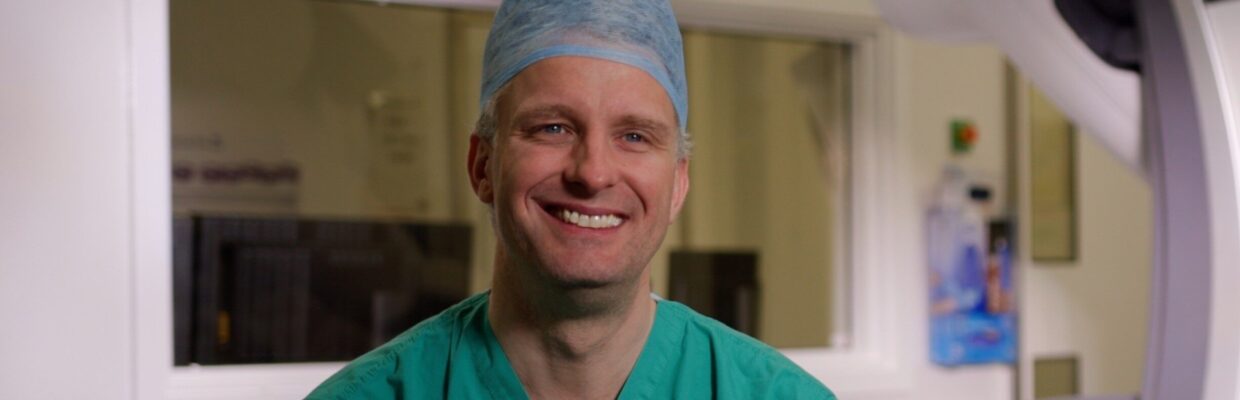 Image of a surgeon in scrubs smiling