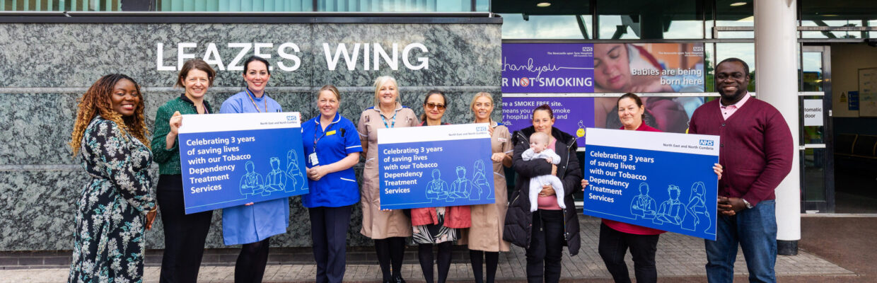 A group of people standing outside the Leazes Wing at the RVI holding posters celebrating saving lives with the Tobacco Dependency Treatment Services